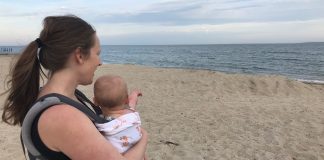 mom on the beach baby wearing her infant