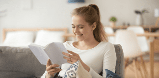 woman reading a parenting book smiling
