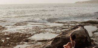 woman sitting on a rock experiencing pandemic burnout