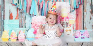baby sitting celebrating her birthday as she turns one