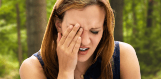 woman holding her face as she gave herself a black eye