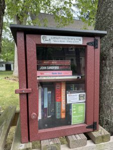 Maroon Little Free Library on Wood stand between trees in a Worcester, MA front yard.