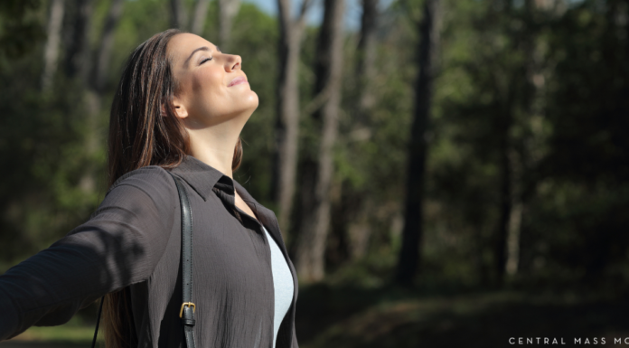 Parenting as a Part of Spring’s Natural Flow woman taking in a deep calming breath outdoors facing into the sunlight