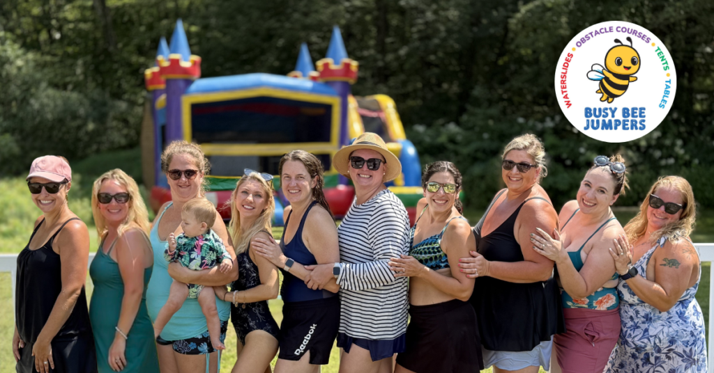 group of moms standing in a line with an inflatable rental bouncy house behind them