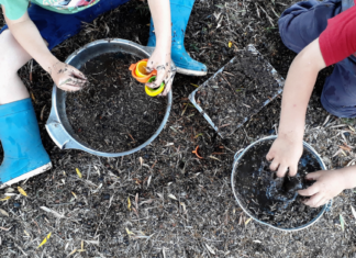 2 kids playing in the dirt with buckets for an inexpensive at-home spring break activity